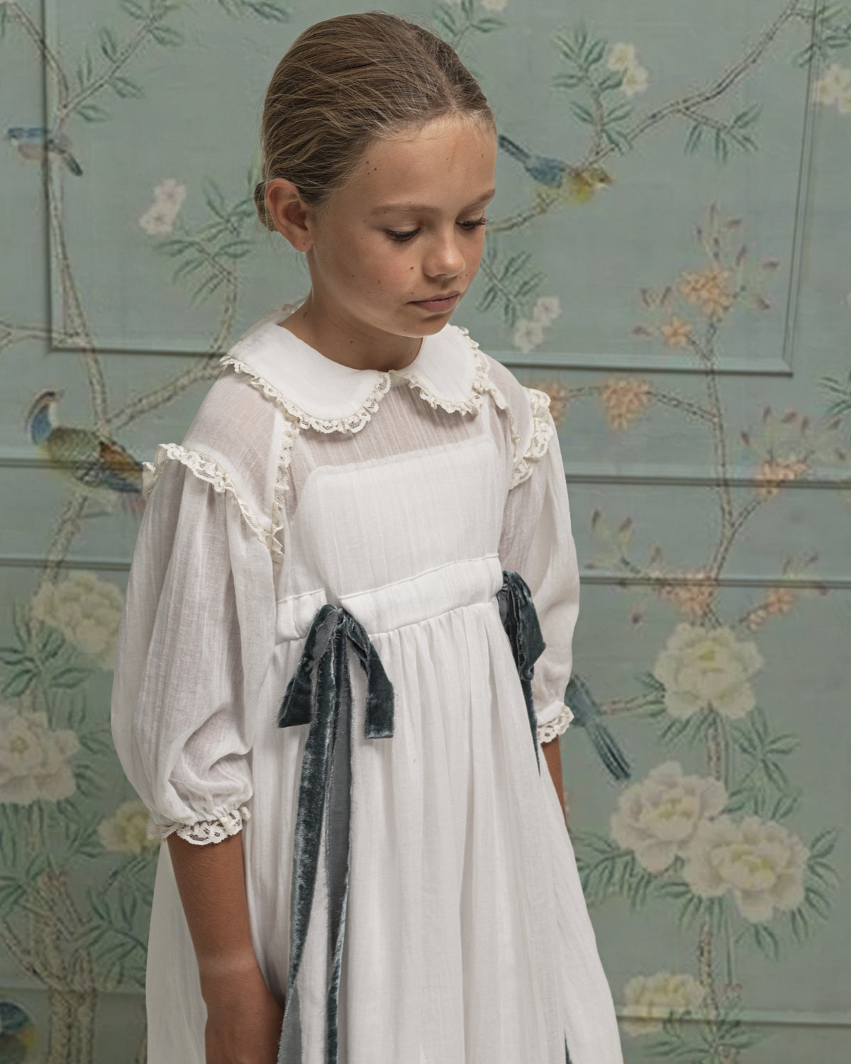 Vestido Primera Comunion con cuello bebe y lazadas en azul de terciopelo. Cosmosophie