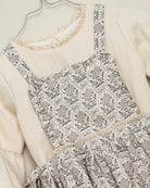 Vestido beige con delantal de flores en azul y gris de Cosmosophie