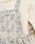 Vestido beige con delantal de flores en azul y gris de Cosmosophie