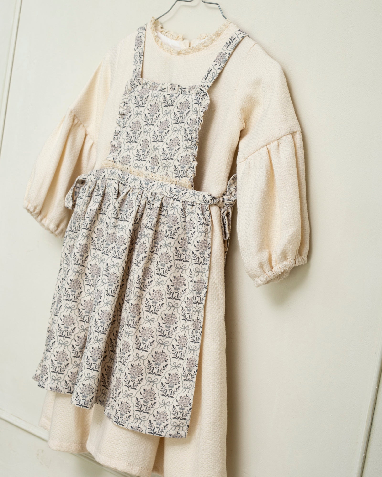 Vestido beige con delantal de flores en azul y gris de Cosmosophie