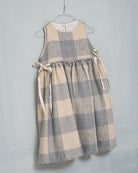 Beautiful pinafore dress in soft oversize gingham fabric in ecru and bluish grey. Perfect to wear with one of our ruffle neck blouses. You will love its bows on the sides.