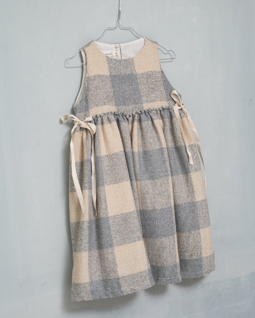 Beautiful pinafore dress in soft oversize gingham fabric in ecru and bluish grey. Perfect to wear with one of our ruffle neck blouses. You will love its bows on the sides.
