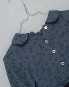 Front button dress with baby collar. You will love its blue double gauze fabric with a print of small black flowers. As details, it has a black ribbon that is tied at the waist.