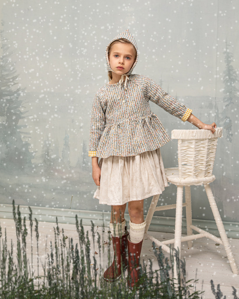 Beautiful jacket made of tweed in ecru, blue and pink tones with a touch of gold. You'll love its yellow gingham detail on the inside and on the sleeve. Perfect to combine with our Homa pinafore dress or romper