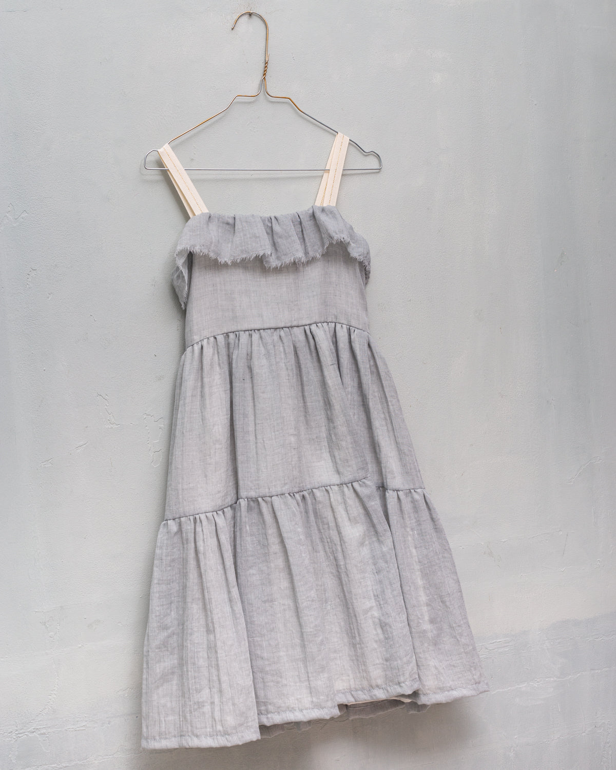 Its ruffled skirt, straps with gold detail, and ruffle on the chest with a frayed finish are the details that make this dress wonderfu