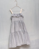 Its ruffled skirt, straps with gold detail, and ruffle on the chest with a frayed finish are the details that make this dress wonderfu