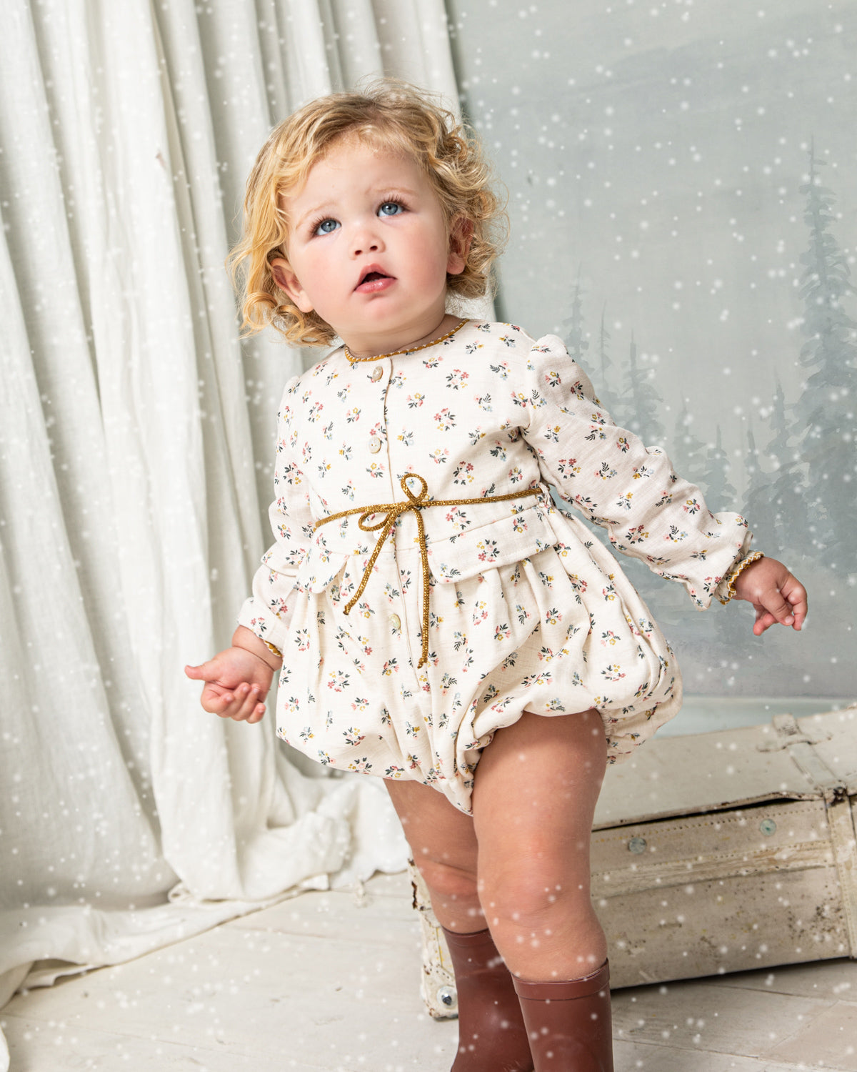 Your baby will look beautiful in this floral print romper in blue, pink and mustard on an ecru background. You'll love the contrasting detail on the neck, its decorative pockets and its tie detail at the waist. Front button closure and between legs. Elasticated cuffs for greater comfort.