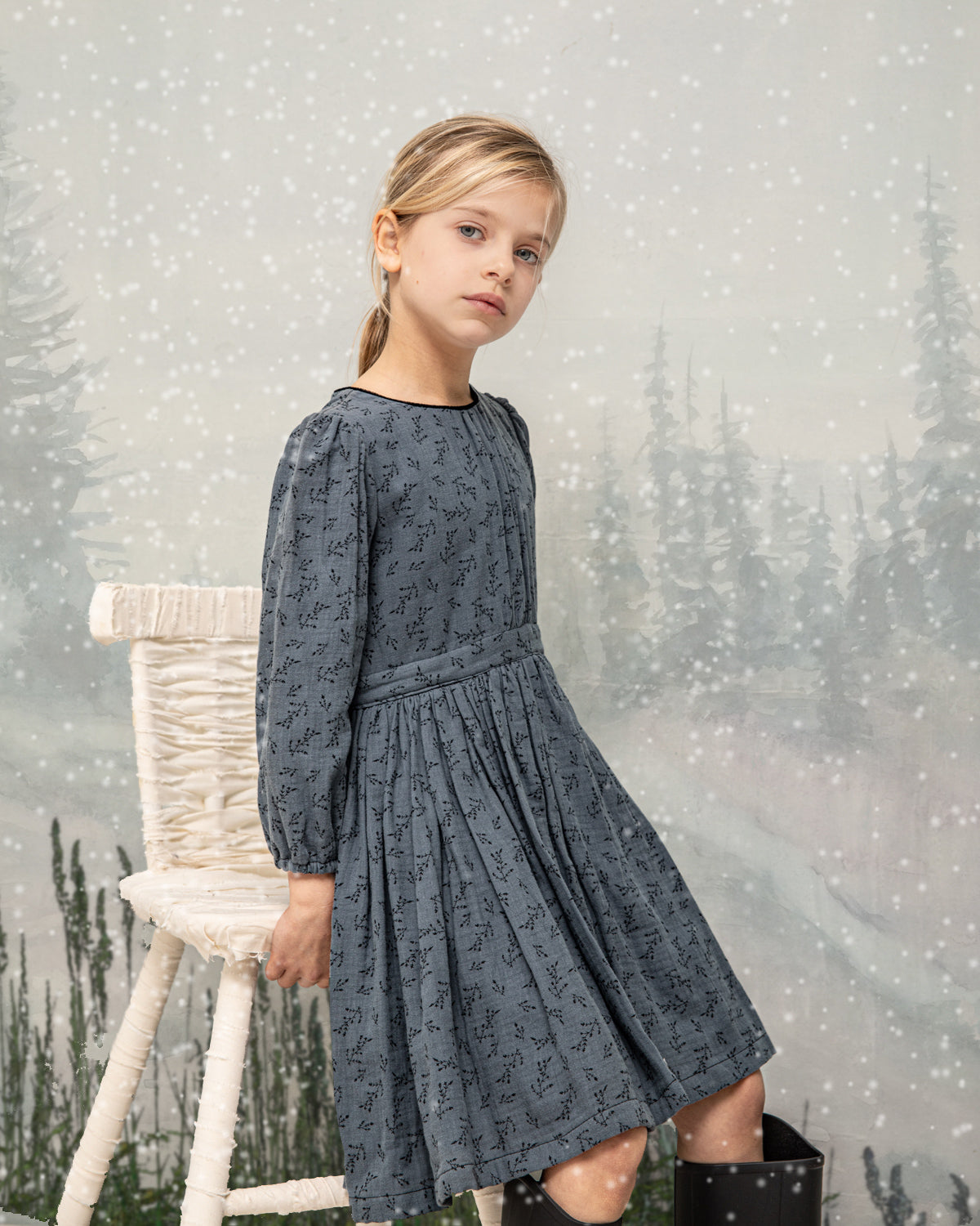 You will love our vintage cut Pandora dress. Contrasting detail on the neck in black. Made in a beautiful double cotton gauze fabric, the print is of small flowers in black on a dark blue background.