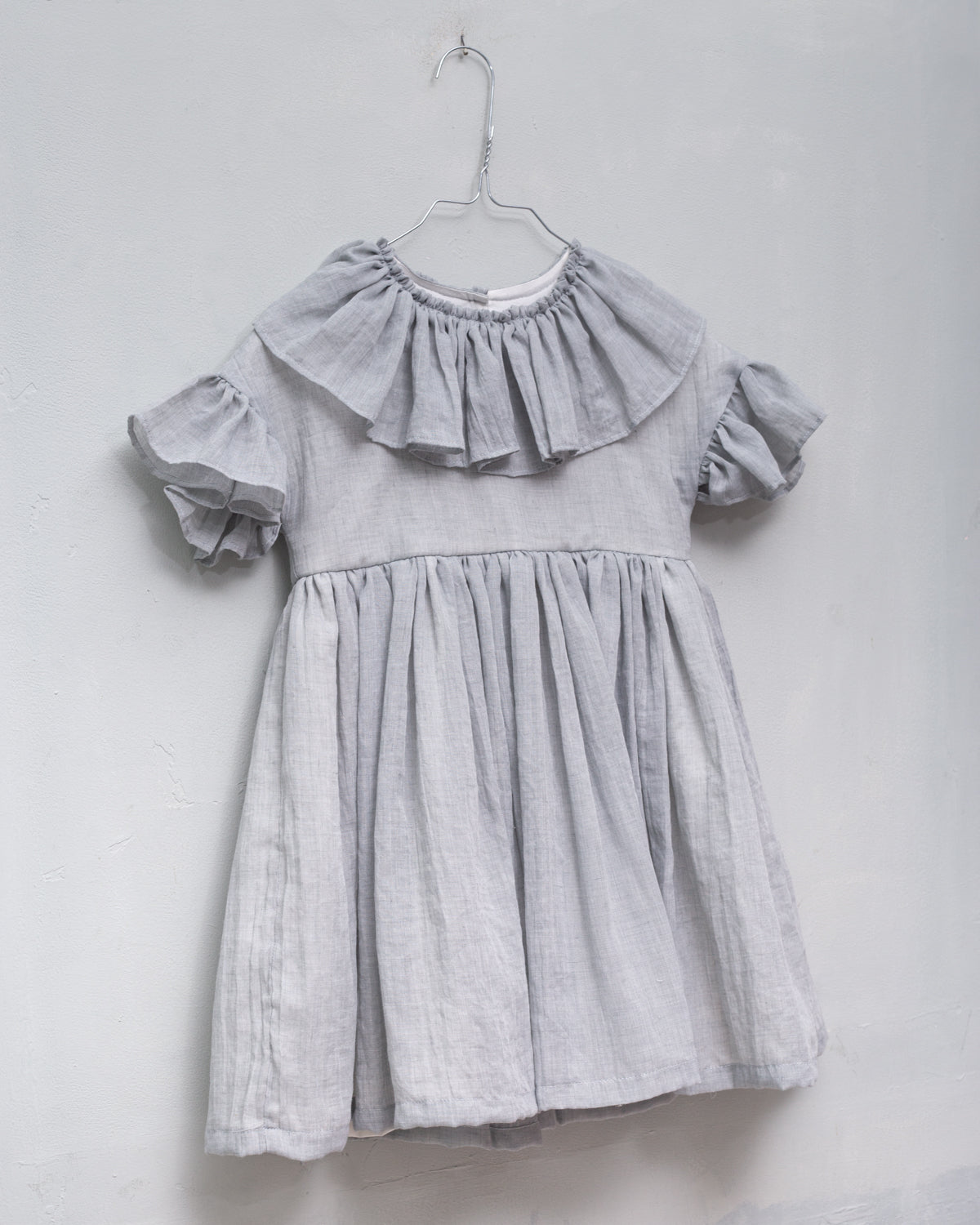 Special occasions dress in light grey. Big peter pan collar. Ruffles on the slevees. Luxury childrens wear eurpean brand