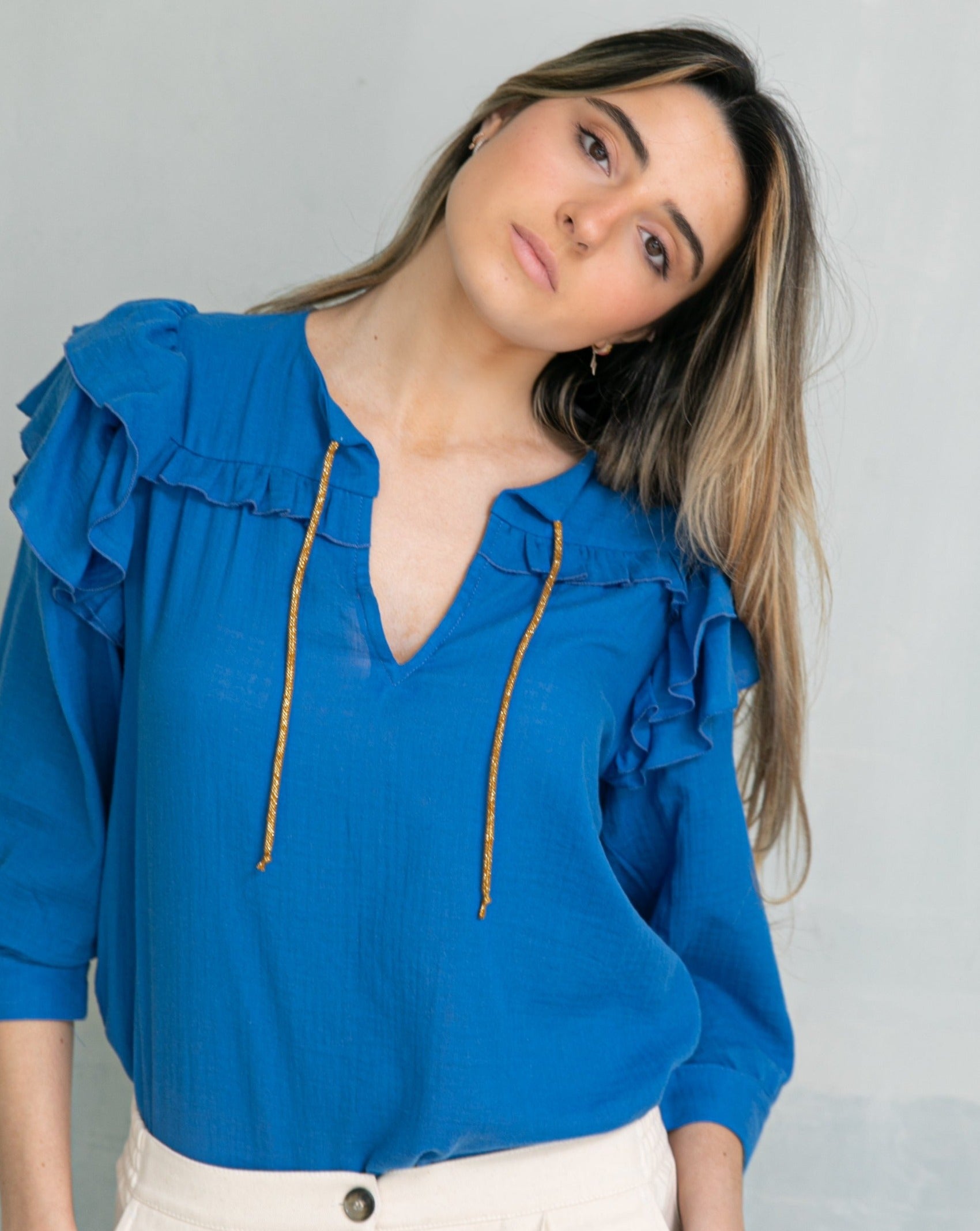 Blusa en algodon vaporoso azul cian con doble volante en el hombro y lazada en oro