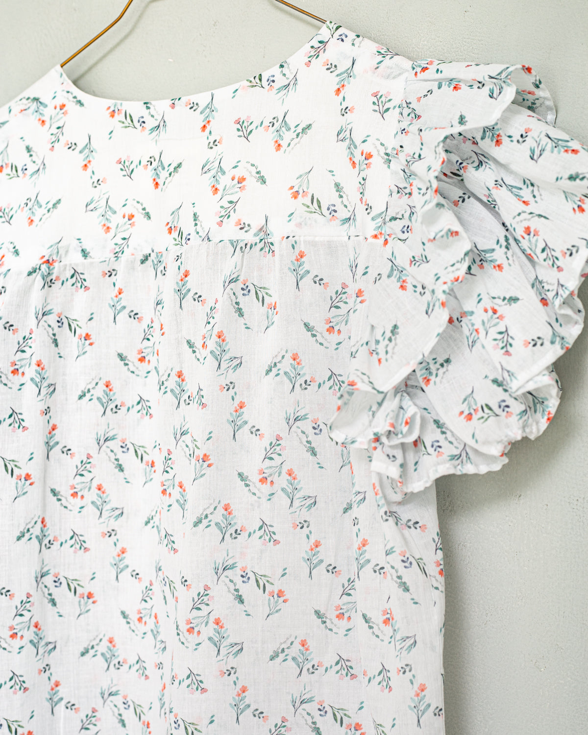 Detalle de blusa de flores romantica tendencia de volantes para una cena. Cosmosophie. Modelo Wolf